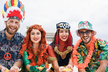 Fully gratified dressed mates celebrating at carnival party with confetti – Focal level on faces