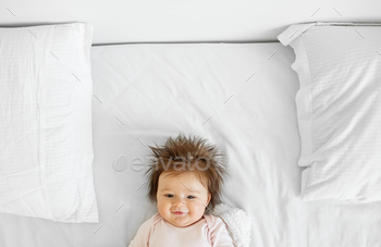 The toddler is 3 months vulnerable. A helpful recent child toddler lady lies on an ideal mattress. Copy condo. Smile