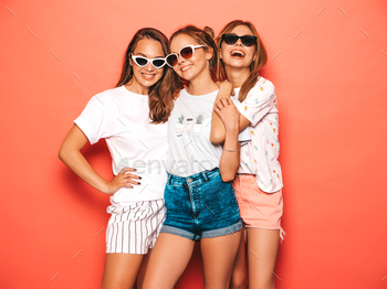 Portrait of three younger mushy ladies people posing in studio