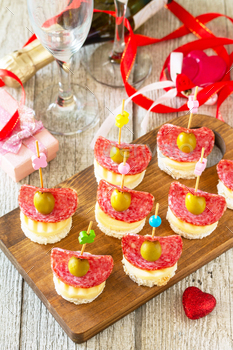 Canapes with bread, cheese, salami and olives.