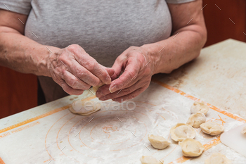 Arms of used girl within the kitchen sculpting dumplings