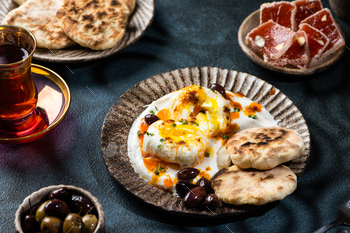 Cilbir or Turkish Eggs. mezze: poached eggs topped over herbed greek yogurt