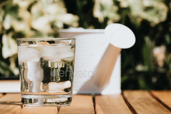 Jug and glass of water on a wood table all over a sunny day summer