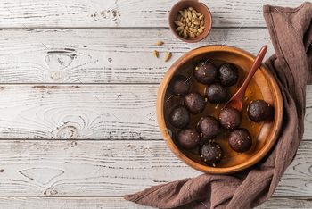 Sweet Gulab Jamun in wooden bowl on rustic background