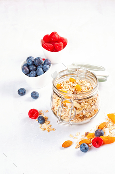 Jar with homemade granola or oatmeal muesli with nuts and dried fruits