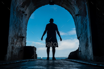 A young man within the tunnel to the sea on the Fort des Capucins a rocky islet located