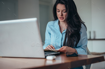 Businesswoman the utilize of a computer and a business planner in an location of work