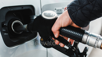 Shut up of hand places gasoline pump into automobile