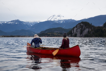 Adventurous other folks on a canoe are taking half in the Canadian Mountain Landscape