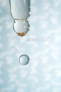 A dripping pipette with a drop of cosmetics gel