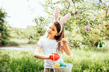 Diminutive one with basket chunky of gleaming eggs. Easter egg hunt