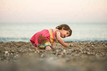 Toddler child taking half in on a seaside