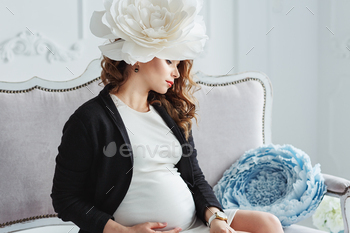 Portrait of younger pregnant lady with white gargantuan flower in her had