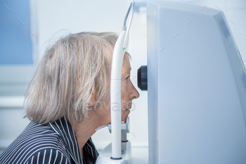 an aged lady on a pc tomograph does a retinal tomography