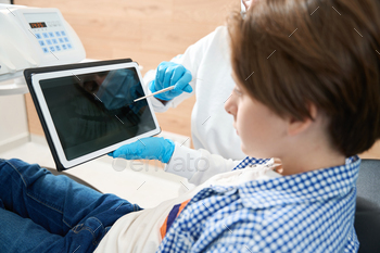 Dentist consulting a younger patient within the dental spot of enterprise