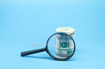 a roll of paper money and a magnifying glass.