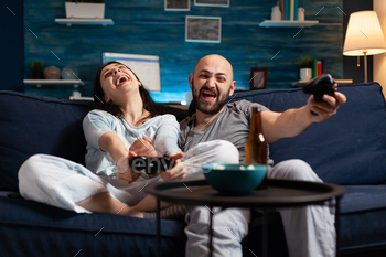 Centered obvious couple taking part in soccer video game slack evening