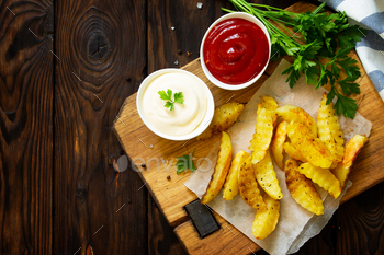 Home made Tasty french fries on decreasing board with Mayonnaise and with ketchup.