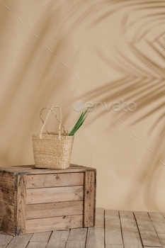 Vertical shot of a straw derive, with a inexperienced plant internal, on a wooden box, with a cream background