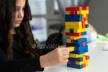 rather tickled lady is taking half within the board sport at the table. Building of a tower made of wooden