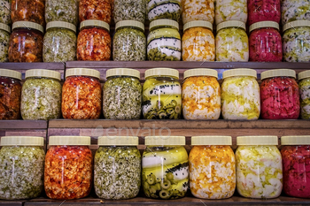 Jars with diversity of pickled greens. Preserved food.