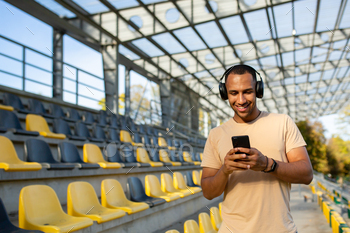 Satisfied and smiling Indian man in park stadium strolling after energetic jogging and health classes