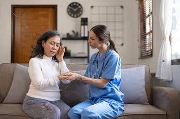 Young female physician leaning forward to aged lady affected person holding her hand in fingers. supporting