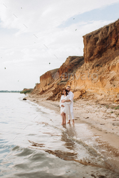 a guy with a girl in white dresses on the seaside