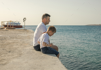 Father and son spending time together sea vacation strolling seaside. Pleased childhood with daddy.