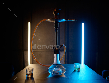 Hookah on table with glasses stuffed brandy in neon gentle