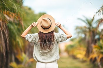 Support inspect of lady in straw hat open air amongst the palmtrees