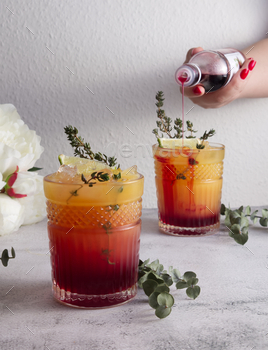 Faceted cocktail glass with beaten ice and lime into which grenadine syrup is poured pack up