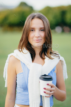 Candid shot of right having a look young European lady with straight hair, dressed in informal outfit