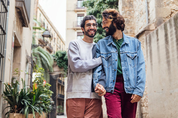 male couple walking embraced and laughing elated