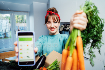 Online dwelling meals delivery. Lady retaining cellular phone with active app with online teach record on the display