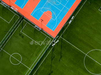 aerial gape of a green football enviornment and a colourful basketball court, providing a look of two