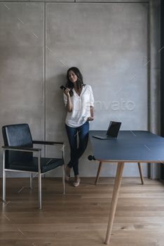 Lady in a room with cell cellular phone and pc