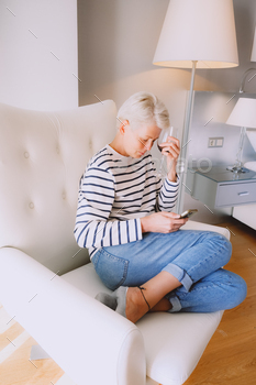 Blonde lady feeling so depressed from unhealthy news whereas checking her cell phone