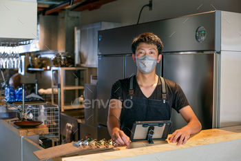 A particular person carrying a face conceal on the counter of a cafe kitchen