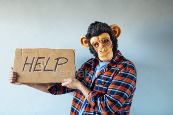 Man with monkey hide and cardboard sign that says HELP.