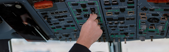 Plane pilot operating overhead panel of airplane flight deck