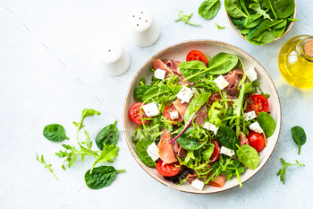 Wholesome salad with inexperienced leaves, tomatoes and jamon.