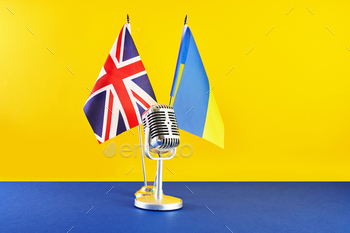 Microphone on a background of a blurry flags Ukraine and Mountainous Britain. European Tune Contest