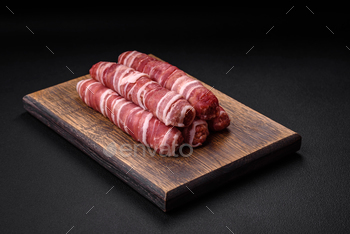 Uncooked minced meat wrapped in bacon with salt and spices or cevapcici