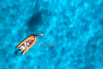 Aerial peep of horny orange boat in blue sea at sunset