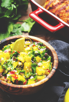 Mango salsa sauce with chili peppers, crimson onion, garlic, lime and cilantro