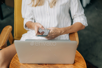 Unrecognizable lady works utilizing digital devices.