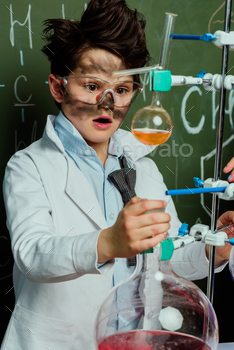 aspect compare of anxious boy in white coat and holding glasses making experiment