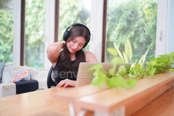 younger girl in cafe with computer and headphone