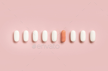 Combine of clinical capsules with one pink pill in a line on gentle pink top demand. Dietary supplements